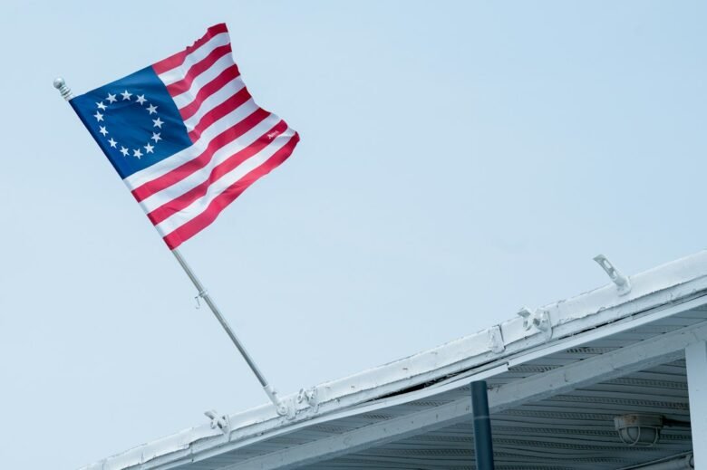 A thirteen-star Betsy Ross flag flying from a building