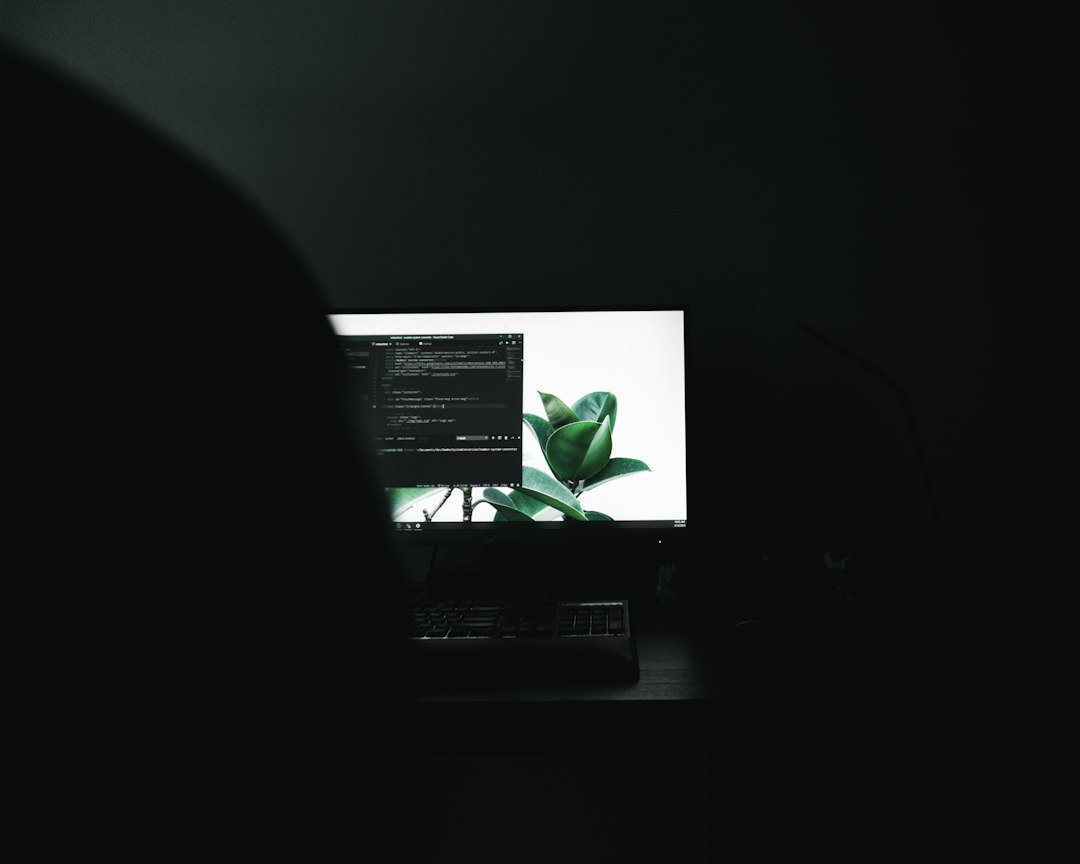 A laptop open on a desk in a dark room