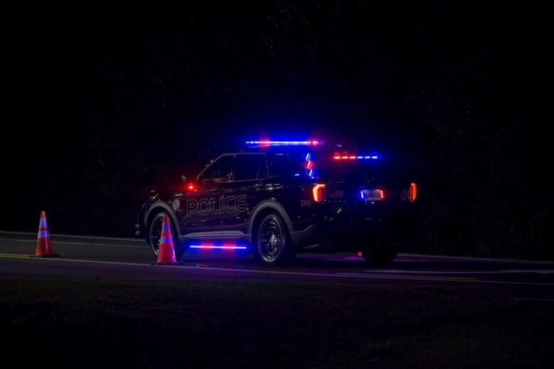 A police vehicle with flashing red and blue emergency lights on a dark road (file photo, not from the Alamo incident)