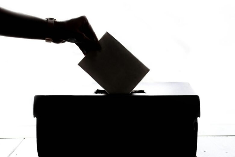 A voter placing a ballot into a ballot box