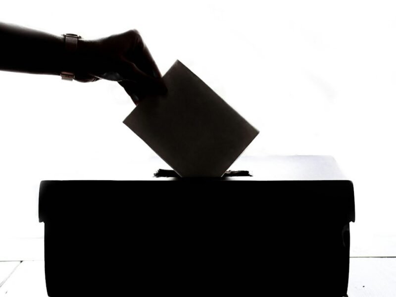 A voter placing a ballot into a ballot box